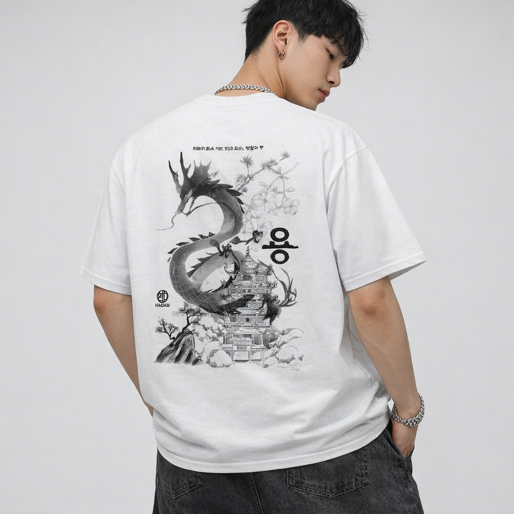Person wearing a white t-shirt with a black dragon design on the back against a plain background